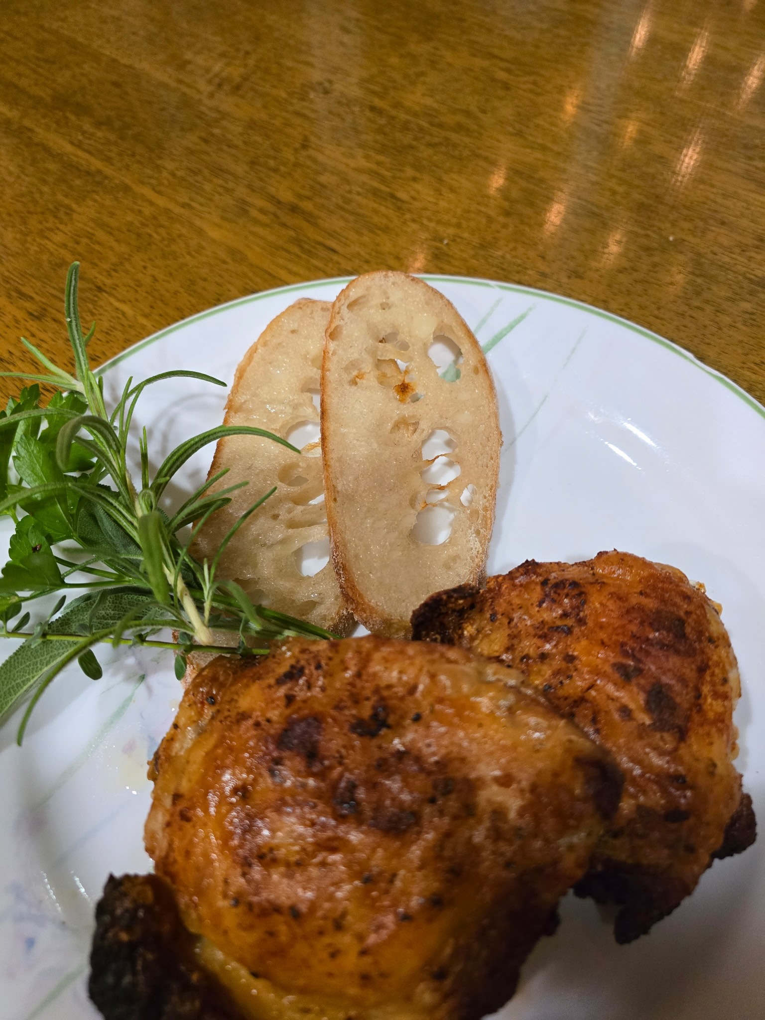 Close-up of mustard-glazed chicken thighs with crispy golden skin and fresh herbs